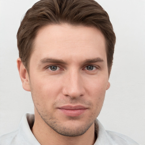 Joyful white young-adult male with short  brown hair and grey eyes