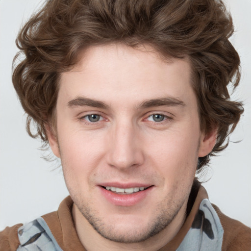 Joyful white young-adult male with short  brown hair and blue eyes