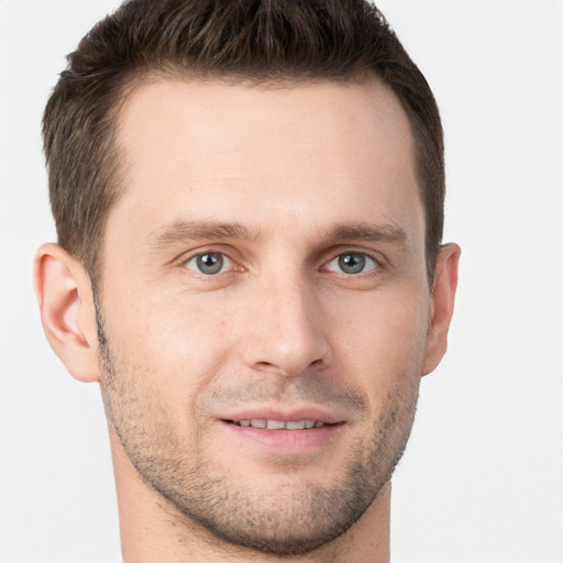 Joyful white young-adult male with short  brown hair and grey eyes