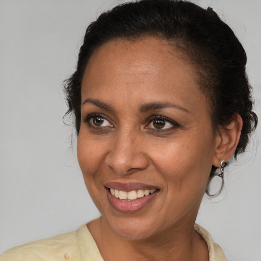 Joyful latino adult female with medium  brown hair and brown eyes