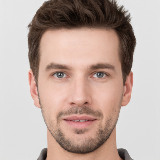 Joyful white young-adult male with short  brown hair and grey eyes