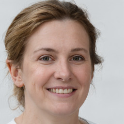 Joyful white adult female with medium  brown hair and grey eyes