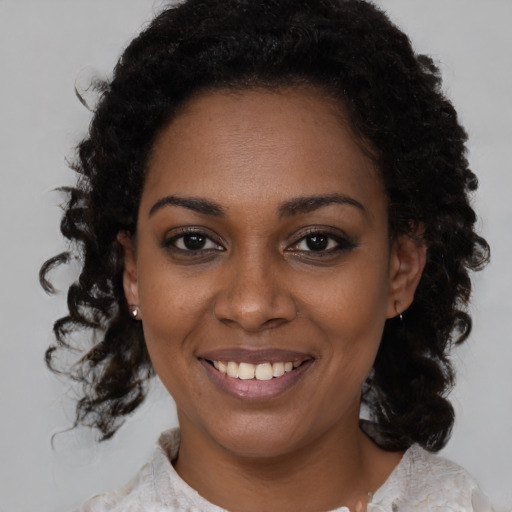 Joyful black young-adult female with medium  brown hair and brown eyes