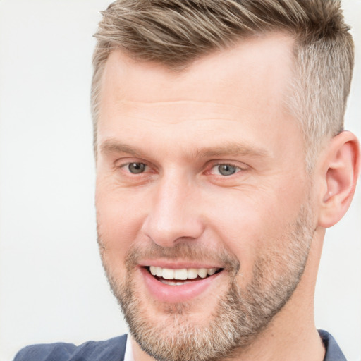 Joyful white adult male with short  brown hair and blue eyes