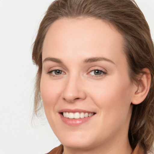 Joyful white young-adult female with long  brown hair and grey eyes