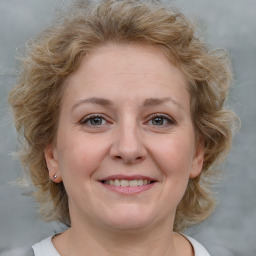 Joyful white young-adult female with medium  brown hair and blue eyes