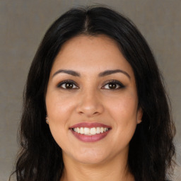 Joyful latino young-adult female with long  brown hair and brown eyes