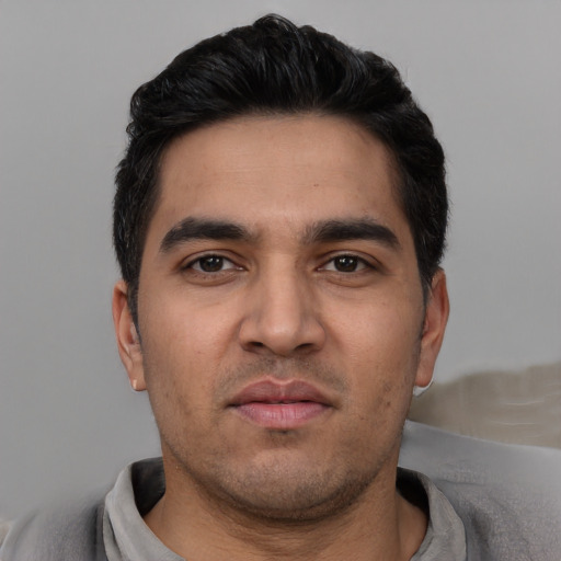 Joyful white young-adult male with short  black hair and brown eyes