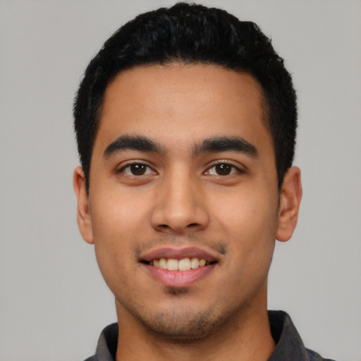 Joyful latino young-adult male with short  black hair and brown eyes