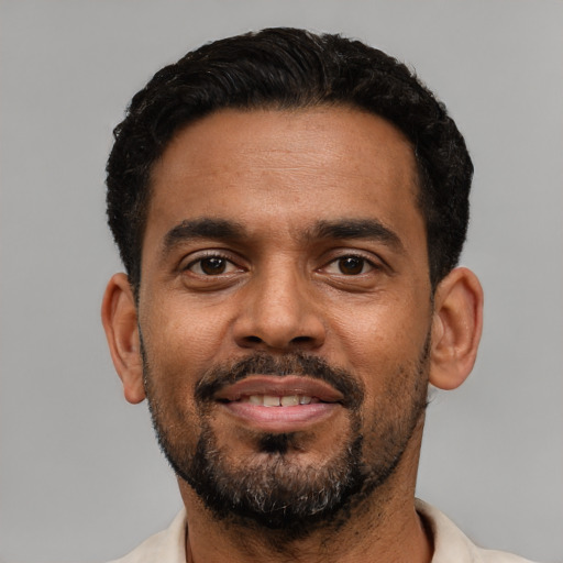 Joyful black young-adult male with short  black hair and brown eyes