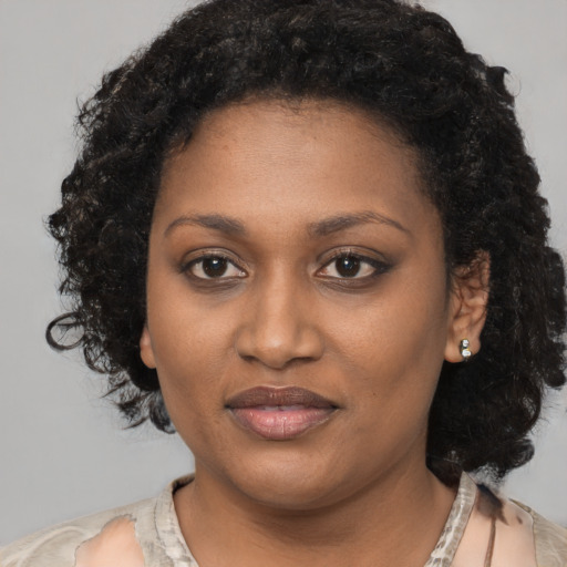 Joyful black young-adult female with short  black hair and brown eyes