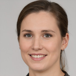 Joyful white young-adult female with medium  brown hair and grey eyes