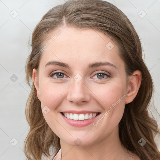 Joyful white young-adult female with long  brown hair and blue eyes