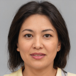 Joyful asian adult female with medium  brown hair and brown eyes