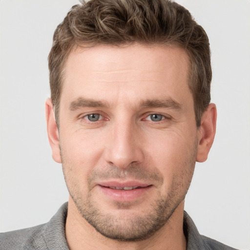 Joyful white young-adult male with short  brown hair and grey eyes