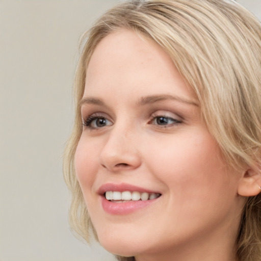 Joyful white young-adult female with long  brown hair and blue eyes