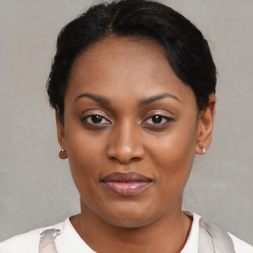 Joyful black young-adult female with short  black hair and brown eyes