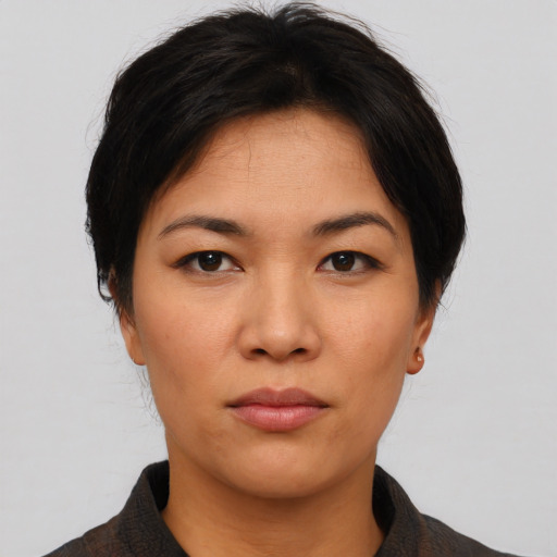 Joyful asian young-adult female with short  black hair and brown eyes