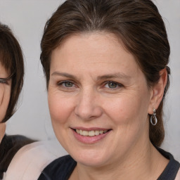 Joyful white adult female with medium  brown hair and brown eyes