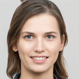 Joyful white young-adult female with long  brown hair and blue eyes