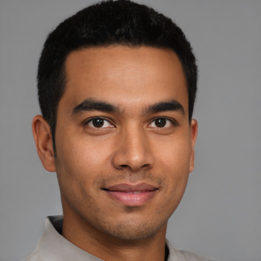 Joyful latino young-adult male with short  brown hair and brown eyes