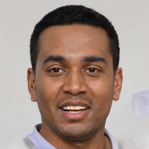 Joyful black young-adult male with short  black hair and brown eyes