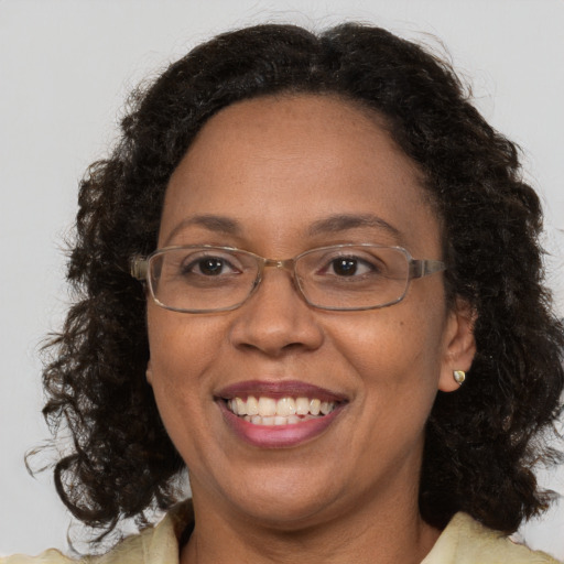 Joyful black adult female with medium  brown hair and brown eyes