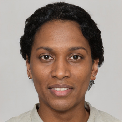 Joyful black adult female with short  black hair and brown eyes