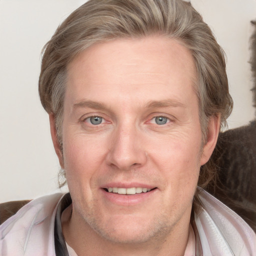 Joyful white adult male with short  brown hair and blue eyes