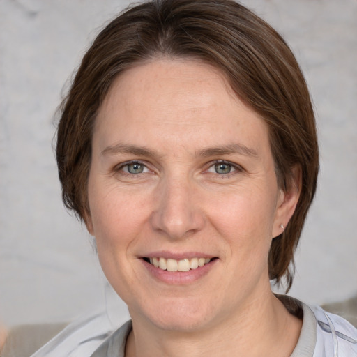 Joyful white adult female with medium  brown hair and grey eyes