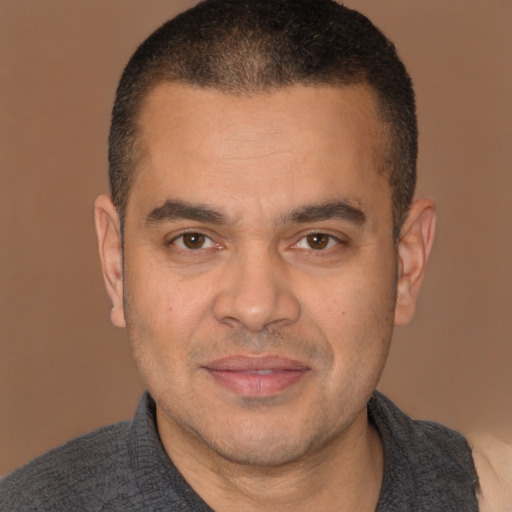 Joyful latino adult male with short  brown hair and brown eyes