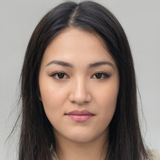 Joyful latino young-adult female with long  brown hair and brown eyes