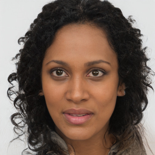 Joyful black young-adult female with long  brown hair and brown eyes