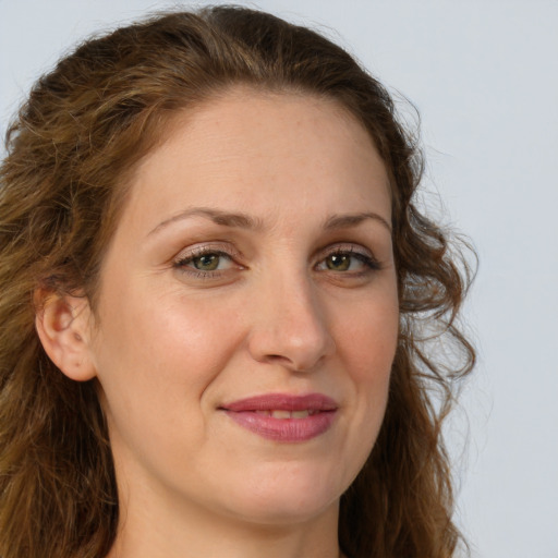 Joyful white adult female with long  brown hair and green eyes