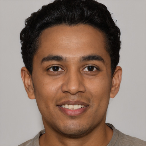 Joyful latino young-adult male with short  black hair and brown eyes
