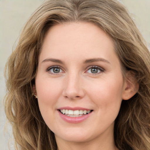 Joyful white young-adult female with long  brown hair and green eyes