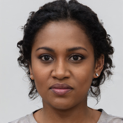 Joyful black young-adult female with medium  black hair and brown eyes