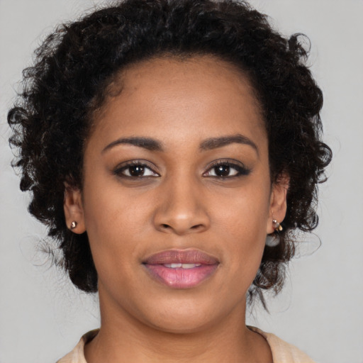 Joyful black young-adult female with long  brown hair and brown eyes