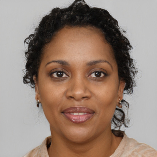 Joyful black adult female with medium  brown hair and brown eyes