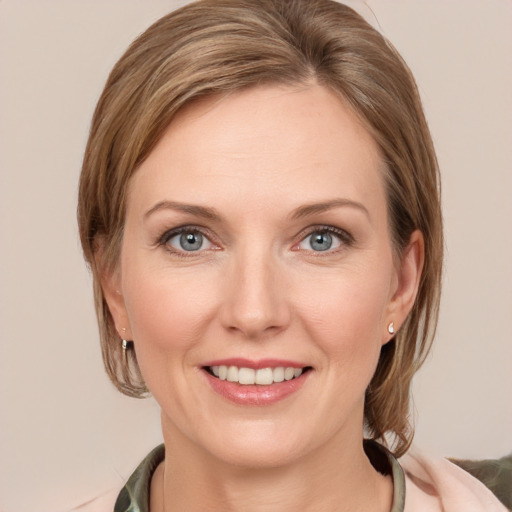 Joyful white young-adult female with medium  brown hair and grey eyes