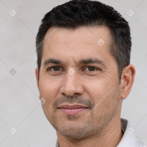 Joyful white adult male with short  black hair and brown eyes