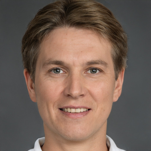 Joyful white adult male with short  brown hair and grey eyes