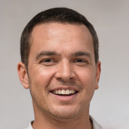 Joyful white young-adult male with short  brown hair and brown eyes