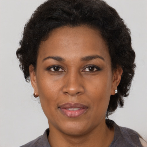 Joyful black adult female with short  brown hair and brown eyes