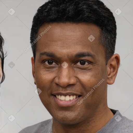 Joyful latino young-adult male with short  black hair and brown eyes