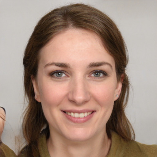 Joyful white young-adult female with medium  brown hair and grey eyes