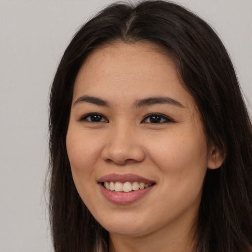 Joyful asian young-adult female with long  brown hair and brown eyes