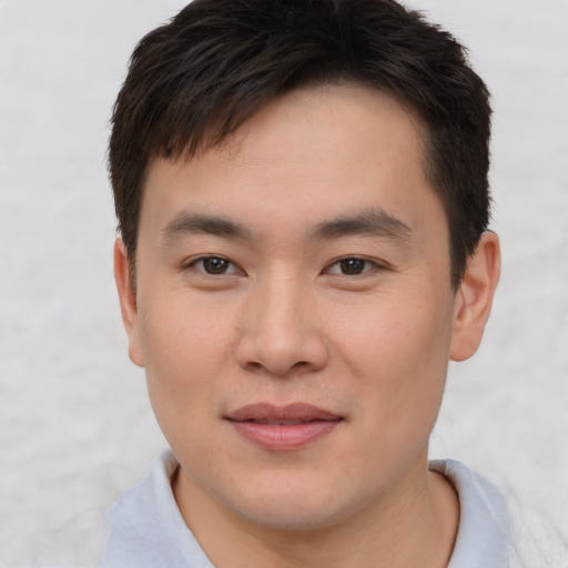 Joyful asian young-adult male with short  brown hair and brown eyes