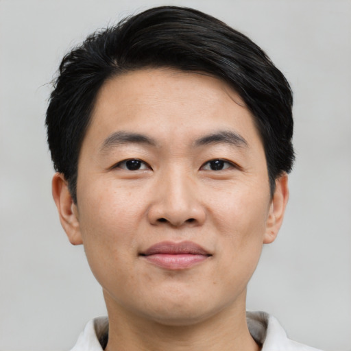 Joyful asian young-adult male with short  black hair and brown eyes