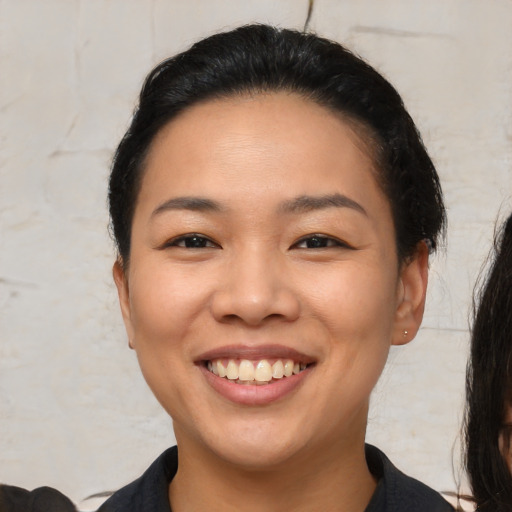 Joyful asian young-adult female with short  black hair and brown eyes